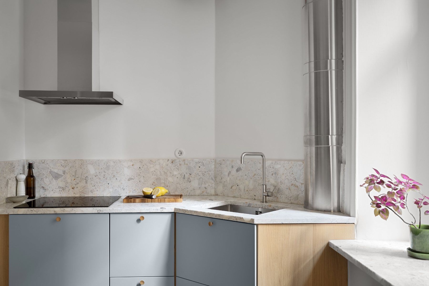 Cuisine aux façades bleu-gris, plan de travail clair et crédence en carreaux de ciment